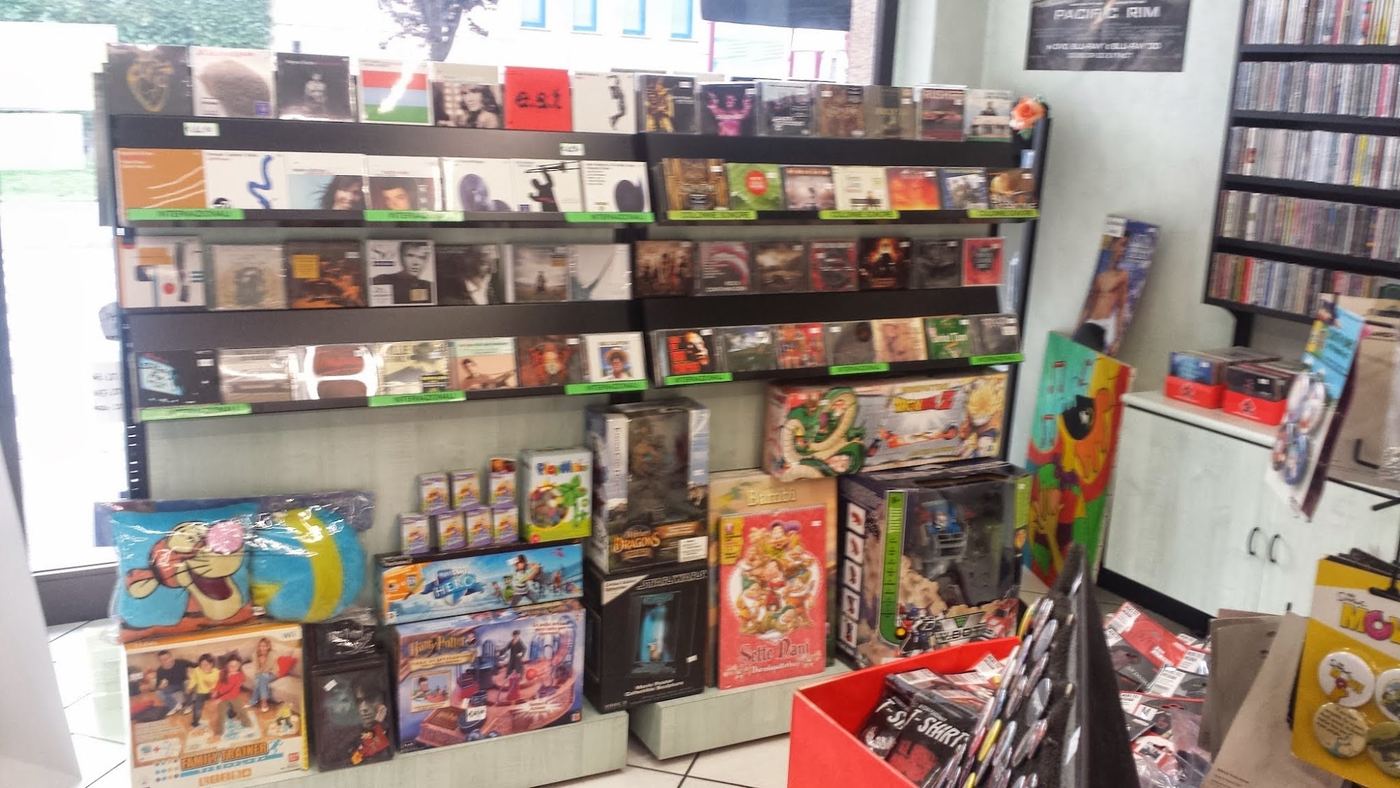 Espositore con dischi e CD delle novità, sotto giochi e statuine da collezione