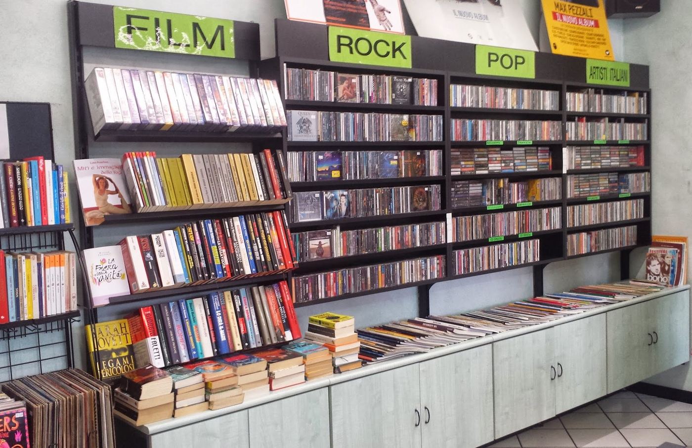 Scaffali con i cartelli verdi Film, Rock, Pop e Artisti italiani