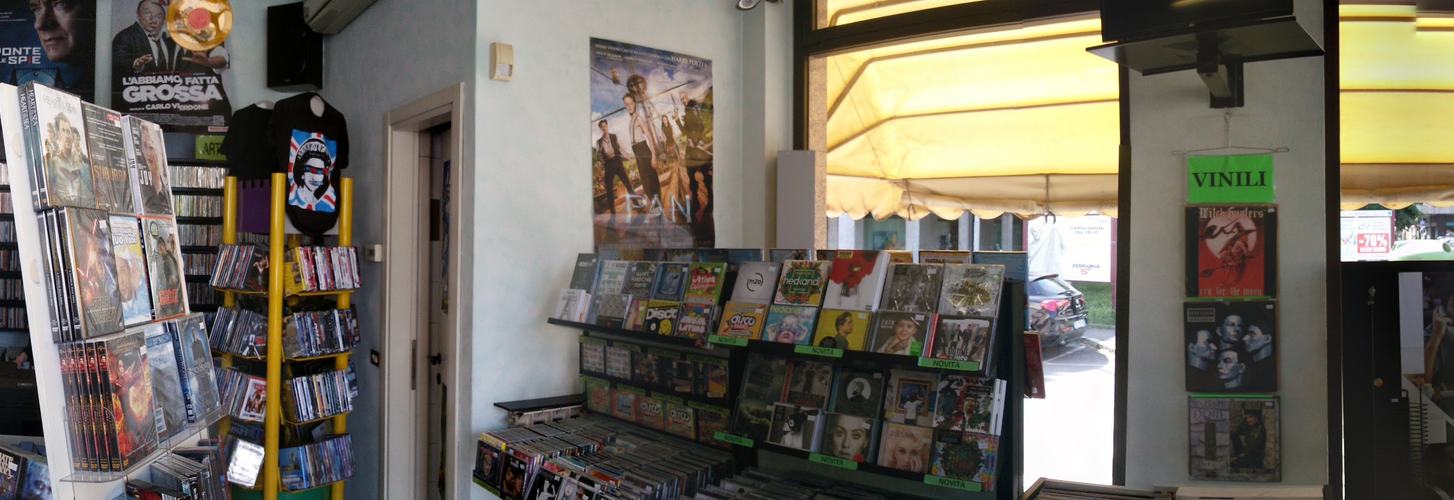 L'interno del negozio con la parete delle spillette, le toppe, le magliette e la torre dei DVD
